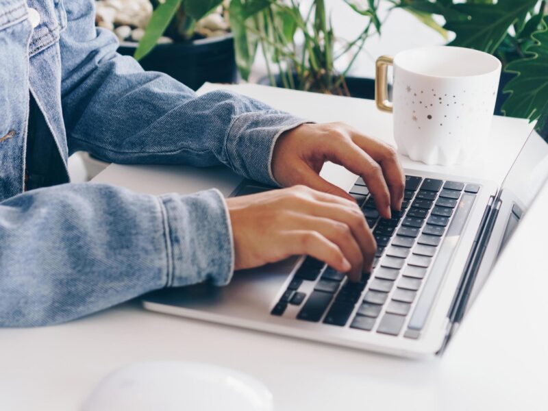 person-using-a-laptop-to-study-on-work-desk-free-photo